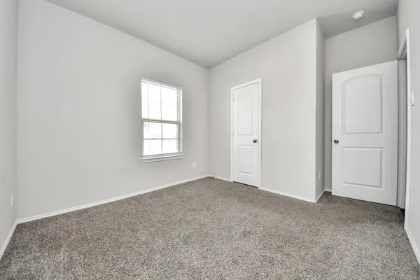 an empty room with windows and closet