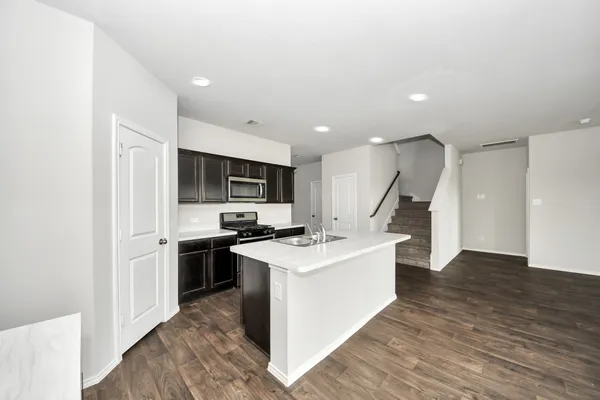 a kitchen with kitchen island a stove a sink and a refrigerator