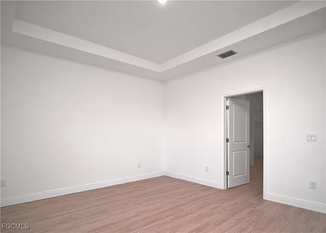 an empty room with wooden floor and closet