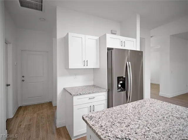 a kitchen with a refrigerator and a stove top oven