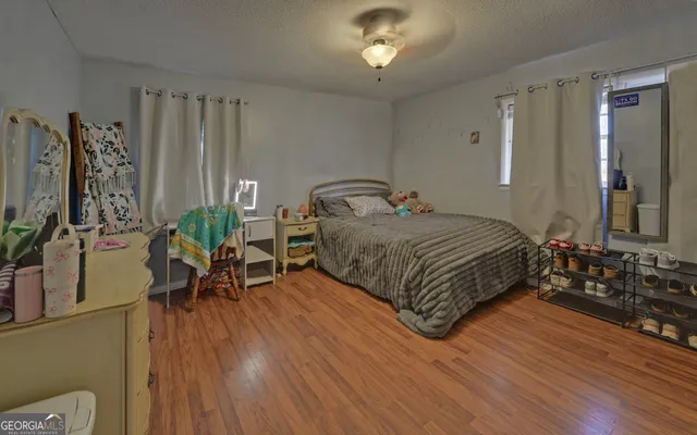 a bedroom with a bed lamps and wooden floor