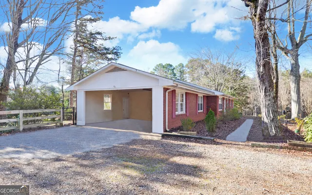 a view of a house with backyard and trees