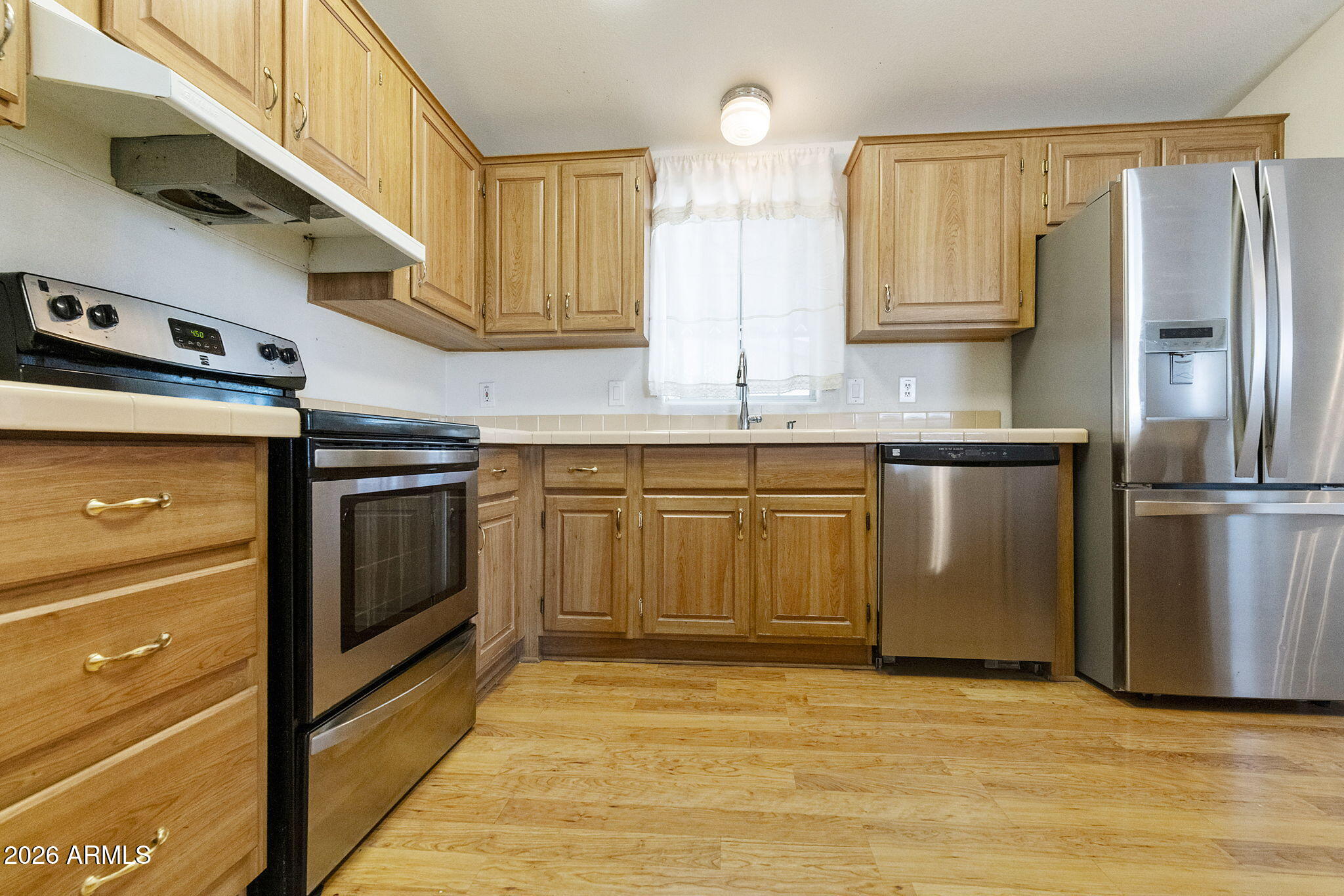 3700 South Tomahawk Road, Unit 73 Apache Junction, AZ 85119 - Photo 12 of 49 a kitchen with stainless steel appliances granite countertop a stove a sink and a refrigerator