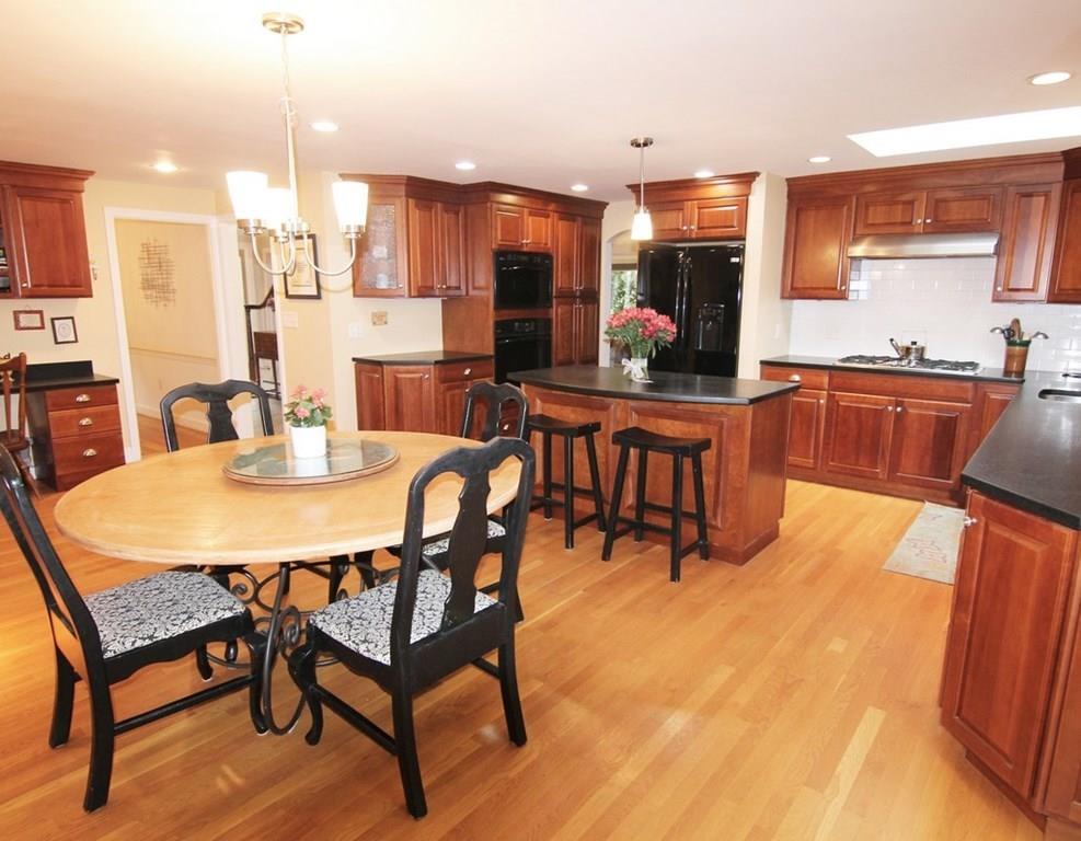 4 Paddock Lane Lexington, MA 02421 - Photo 8 of 25 a dining room filled with stainless steel appliances kitchen island granite countertop a table chairs and a refrigerator