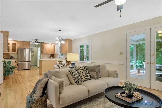 a living room with furniture kitchen and a chandelier