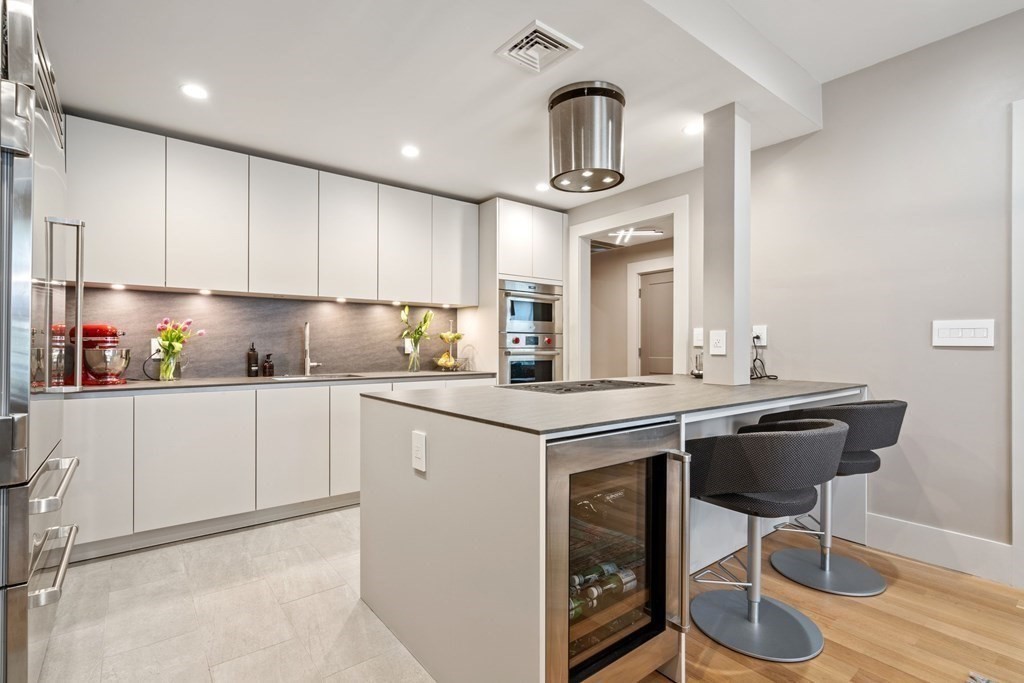 135 Beaconsfield Road, Unit 2 Brookline, MA 02445 - Photo 16 of 33 a kitchen with kitchen island granite countertop a sink cabinets and wooden floor