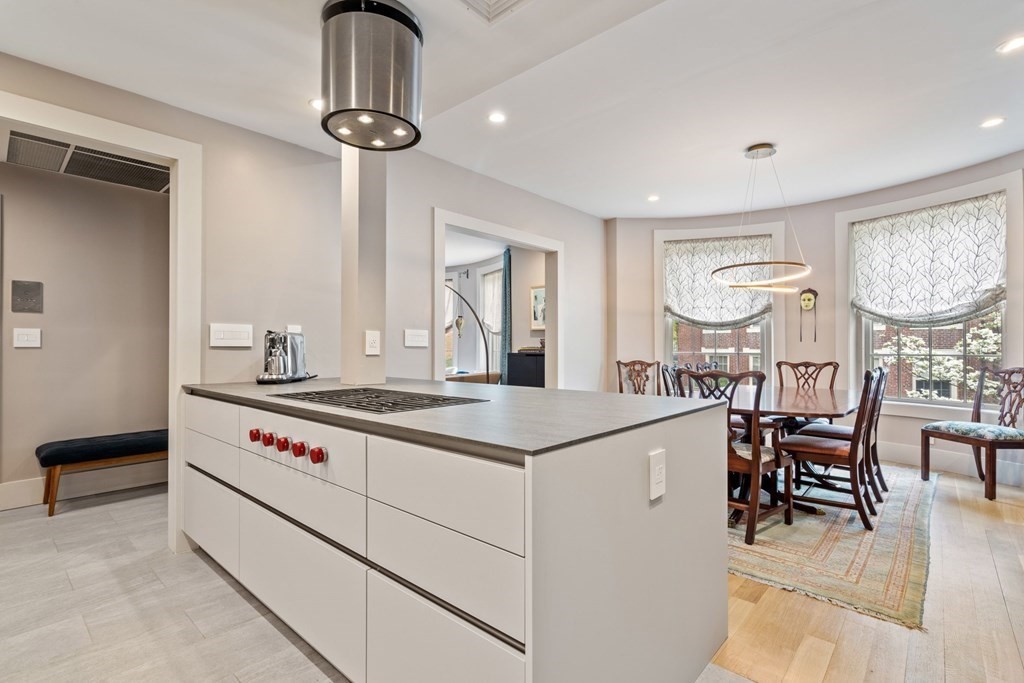 135 Beaconsfield Road, Unit 2 Brookline, MA 02445 - Photo 2 of 33 a kitchen with a stove a chandelier and a dining table