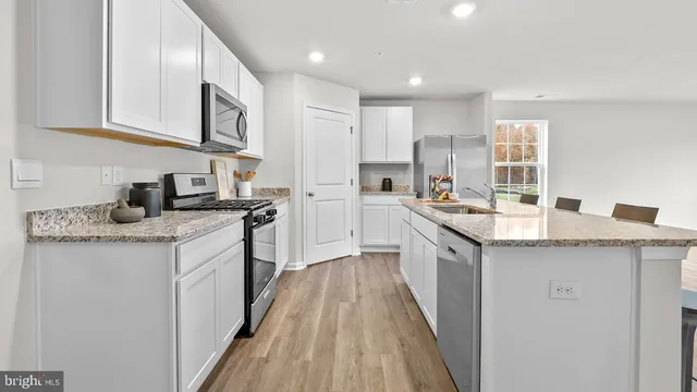 a kitchen with stainless steel appliances granite countertop a sink stove and cabinets