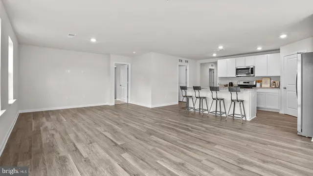 a view of kitchen with stainless steel appliances granite countertop a stove top oven a refrigerator and a cabinets