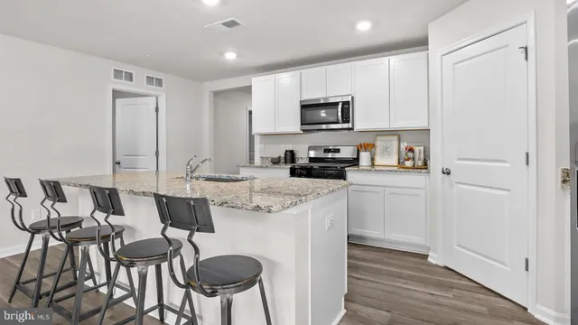 a kitchen with stainless steel appliances a table and chairs in it