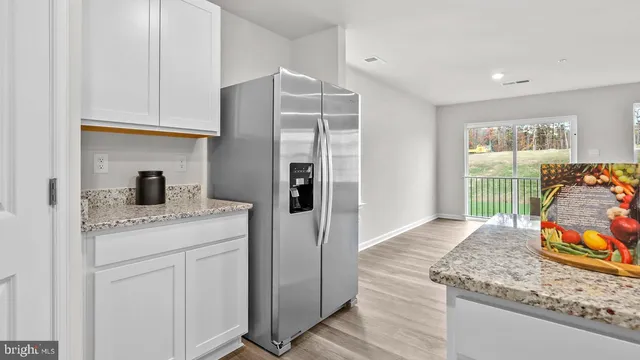 a kitchen with stainless steel appliances granite countertop a refrigerator and a sink