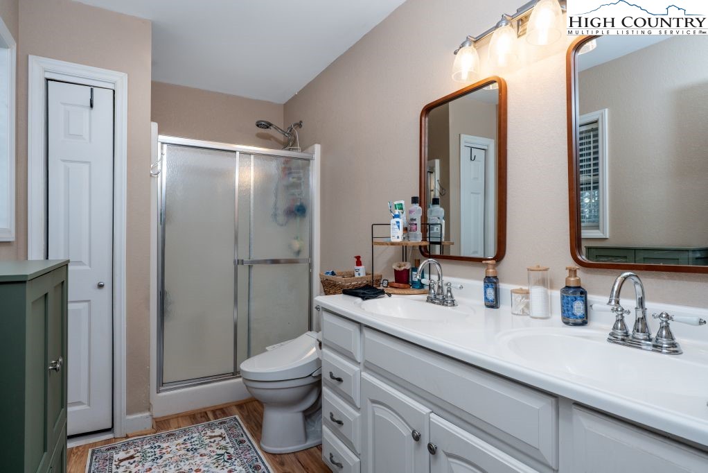 3564 Hickory Nut Gap Road Newland, NC 28657 - Photo 17 of 35 a bathroom with a double vanity sink toilet and shower