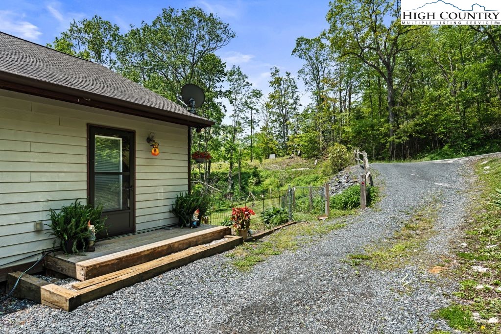 3564 Hickory Nut Gap Road Newland, NC 28657 - Photo 25 of 35 a backyard of a house with potted plants and large tree