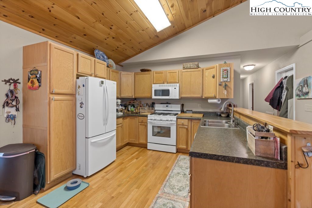 3564 Hickory Nut Gap Road Newland, NC 28657 - Photo 8 of 30 a kitchen with granite countertop a refrigerator a stove top oven a sink and dishwasher