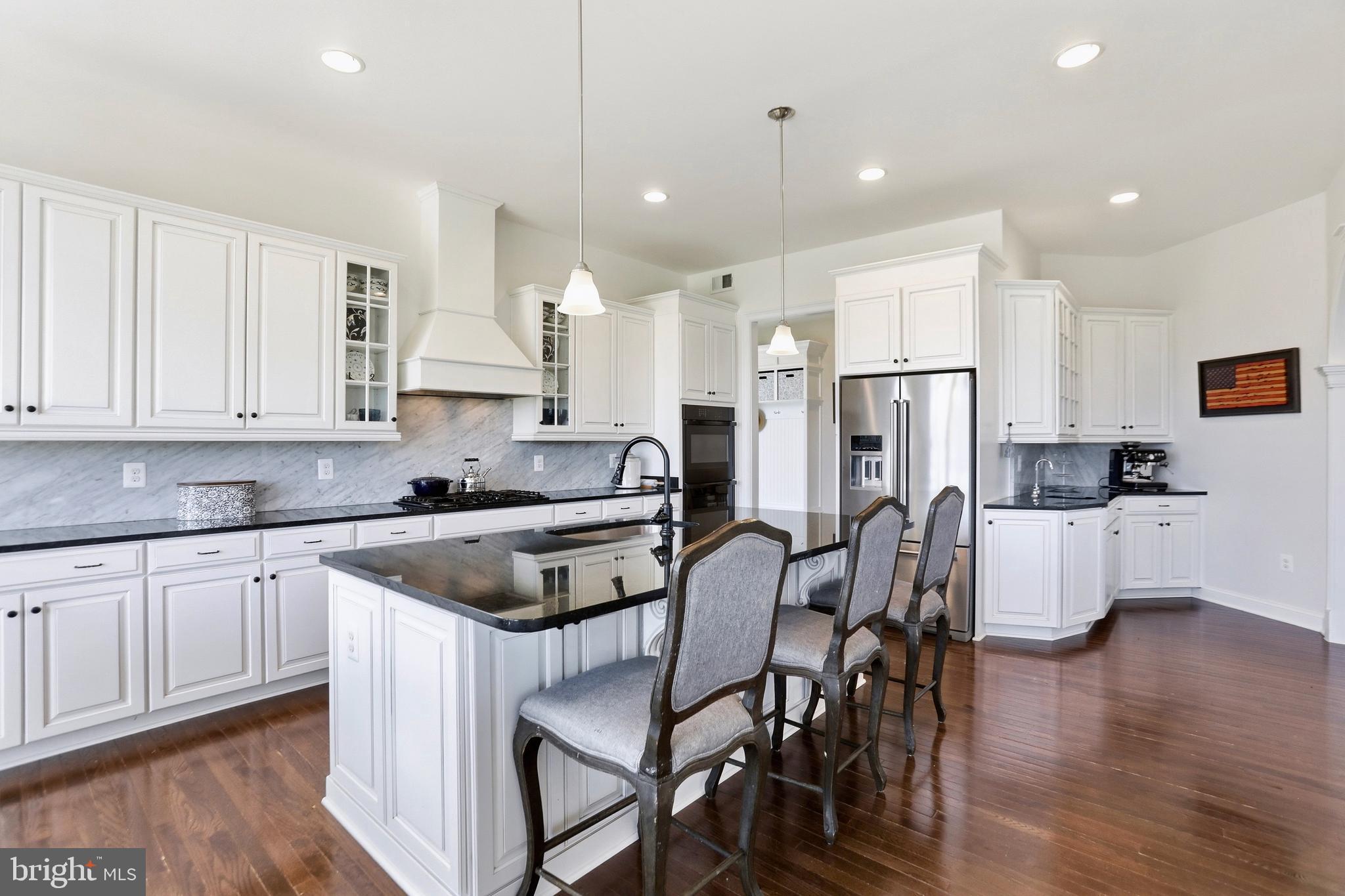 36972 Bridle Ridge Lane Purcellville, VA 20132 - Photo 11 of 44 a kitchen with stainless steel appliances granite countertop a stove top oven a refrigerator a sink and white cabinets with wooden floor next to windows