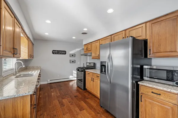 a kitchen with granite countertop stainless steel appliances cabinets a sink and a counter top space