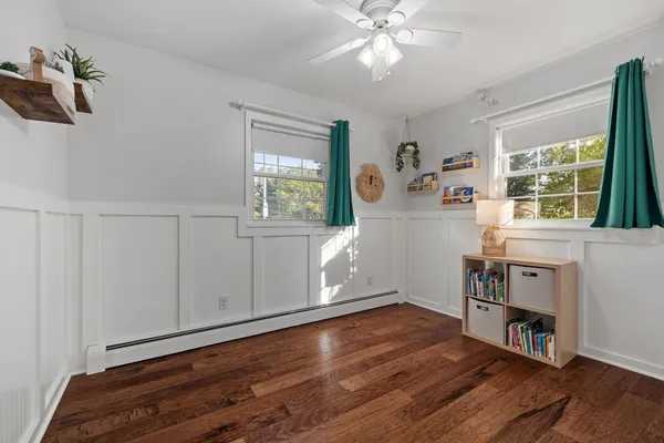 a view of a livingroom with furniture hardwood floor cabinet and windows