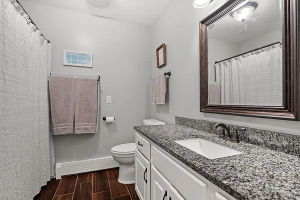 a bathroom with a granite countertop sink and a mirror
