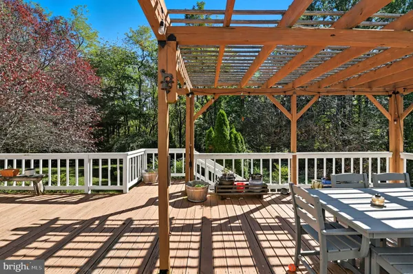 a view of a patio with table and chairs with wooden floor and fence