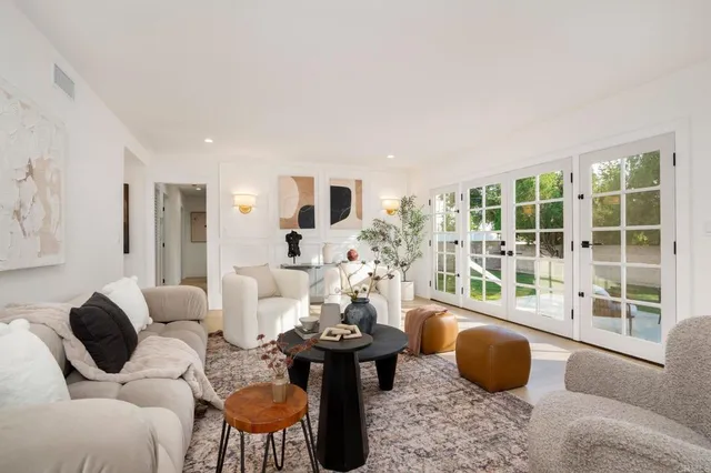 a living room with furniture a table and a large window