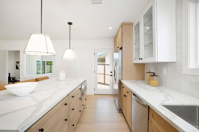 a kitchen with granite countertop white cabinets and white appliances