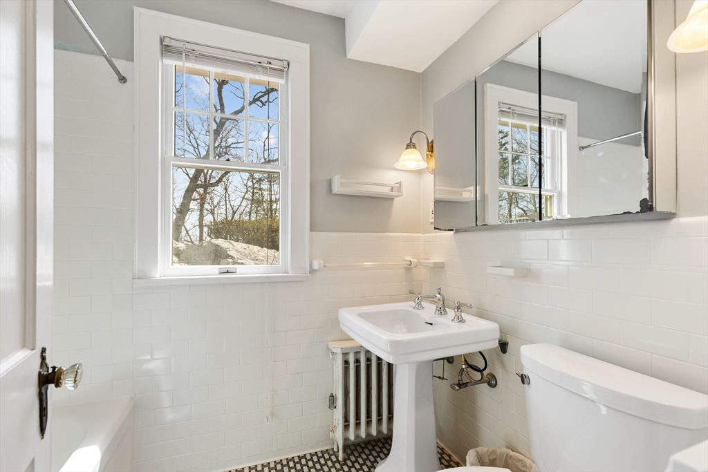 71 Woodland Road Malden, MA 02148 - Photo 23 of 41 a bathroom with a sink a mirror and a toilet