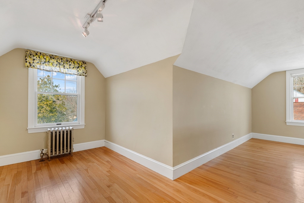71 Woodland Road Malden, MA 02148 - Photo 25 of 41 an empty room with wooden floor and windows