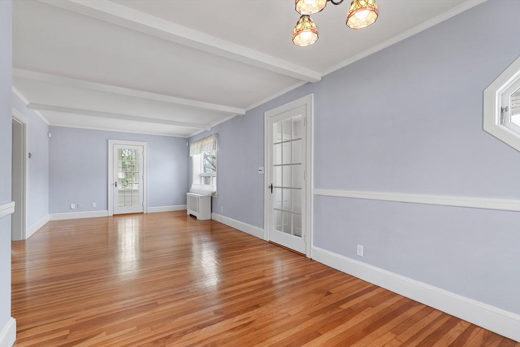 71 Woodland Road Malden, MA 02148 - Photo 7 of 41 a view of an empty room with wooden floor and window