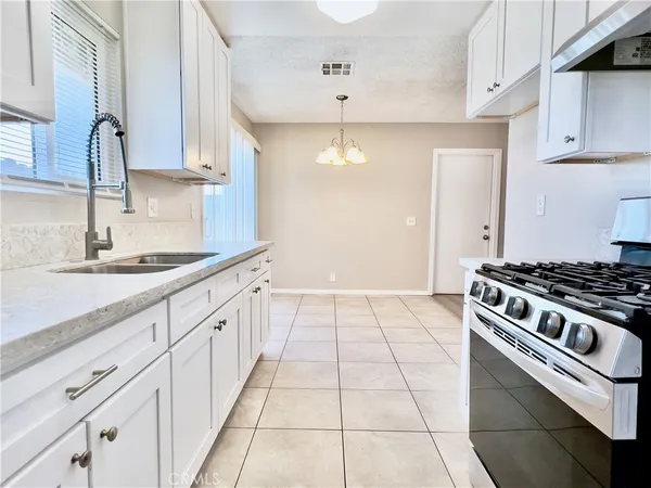 a kitchen with granite countertop white cabinets and sink