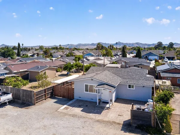 an aerial view of a house with a yard garage and lake view in back