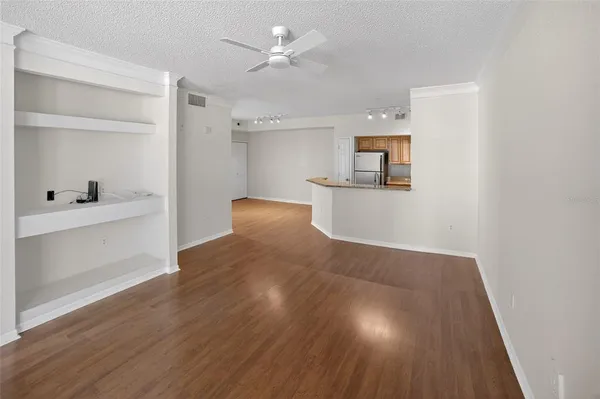 a view of a kitchen with wooden floor and a ceiling fan