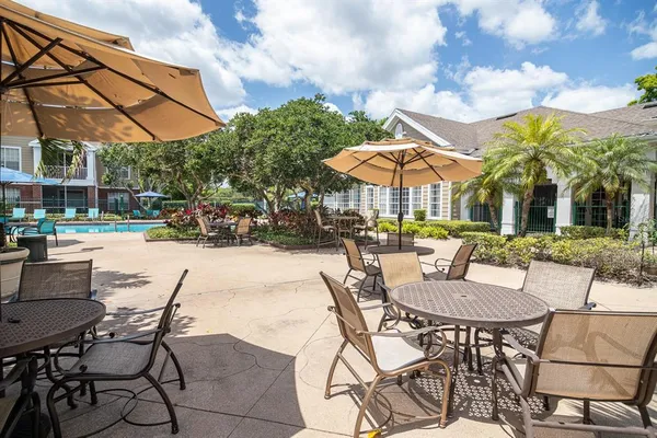 a view of swimming pool with lounge chair and dinning table under an umbrella