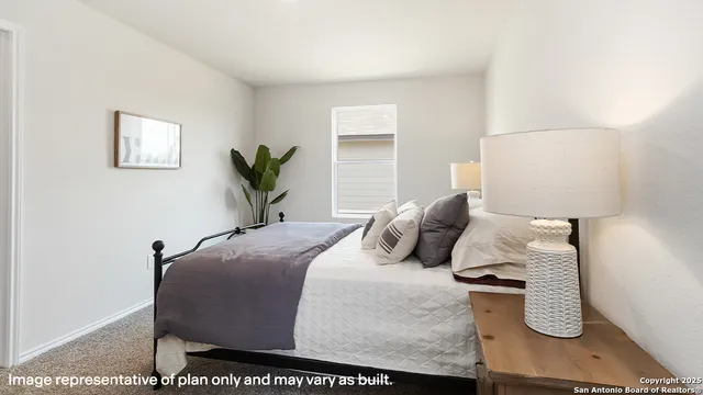 a bedroom with a bed and a potted plant