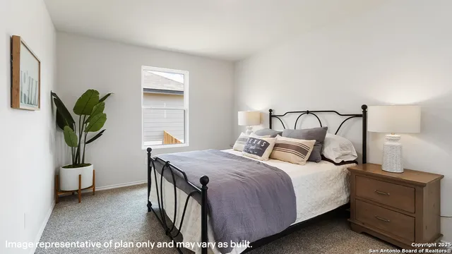 a bedroom with a bed and a potted plant