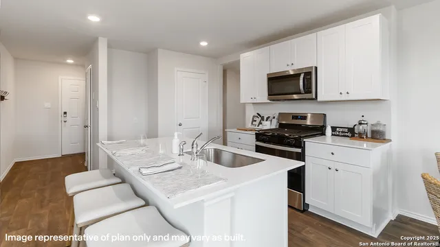 a kitchen with stainless steel appliances granite countertop a sink a stove and a refrigerator