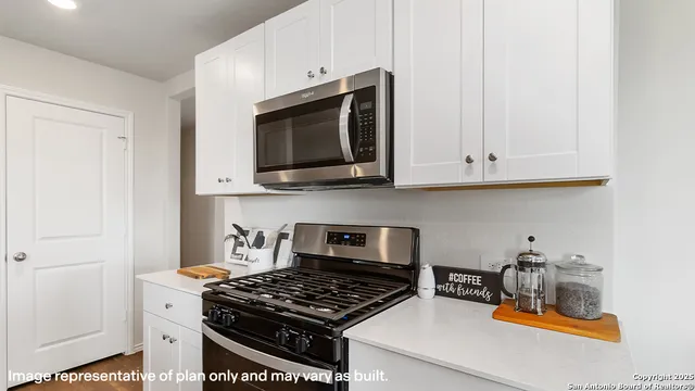 a kitchen with stainless steel appliances granite countertop a stove a microwave and cabinets