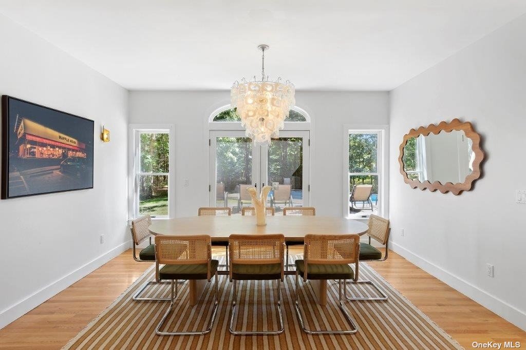 4 East Hampton, undefined 00000 - Photo 15 of 20 a dining room with wooden floor a chandelier a glass table and chairs