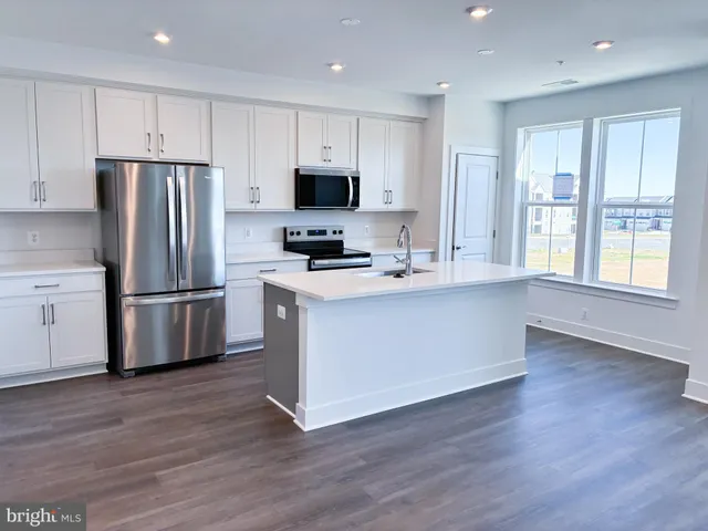 a kitchen with stainless steel appliances a refrigerator sink and microwave