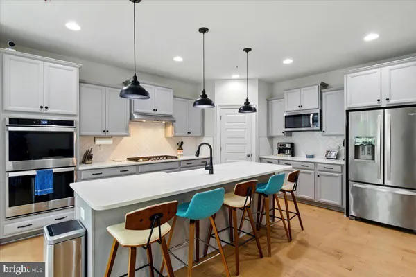 a kitchen with stainless steel appliances a stove a sink refrigerator and a refrigerator