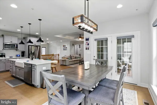 a very nice looking dining room with kitchen island stainless steel appliances a sink a stove center island and couches