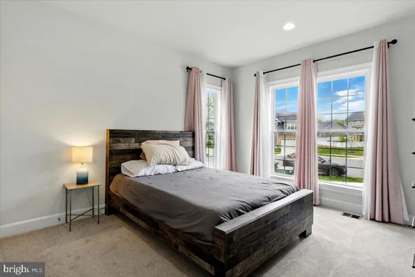 a bed sitting in a spacious bedroom next to a window