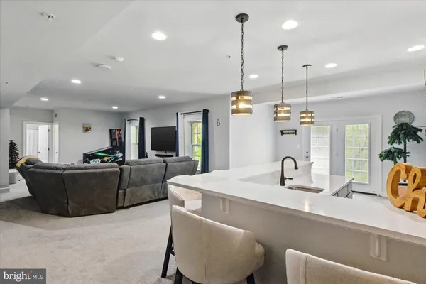 a kitchen with stainless steel appliances kitchen island granite countertop a sink a refrigerator and a coffee maker