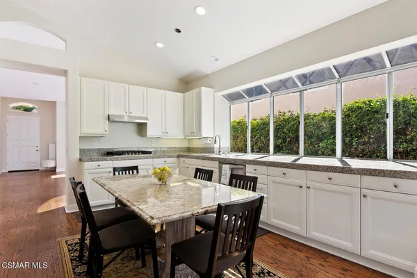 a kitchen that has a dining table and chairs in it