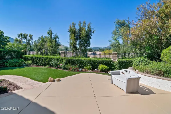 a view of a white house with a yard and sitting area