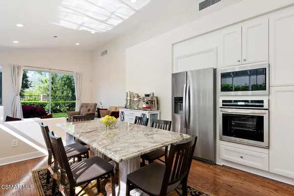 a kitchen with a table chairs refrigerator and microwave
