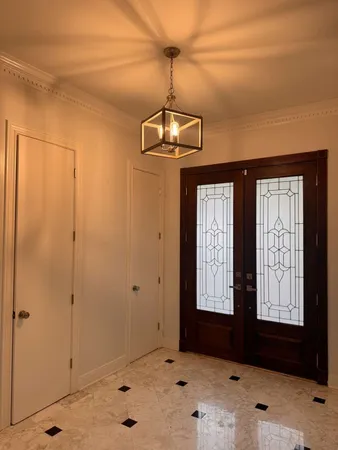 a view of a hallway with windows and chandelier