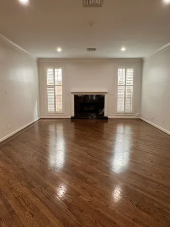 a view of empty room with wooden floor and fireplace
