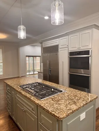 a kitchen with kitchen island granite countertop stainless steel appliances a stove and refrigerator