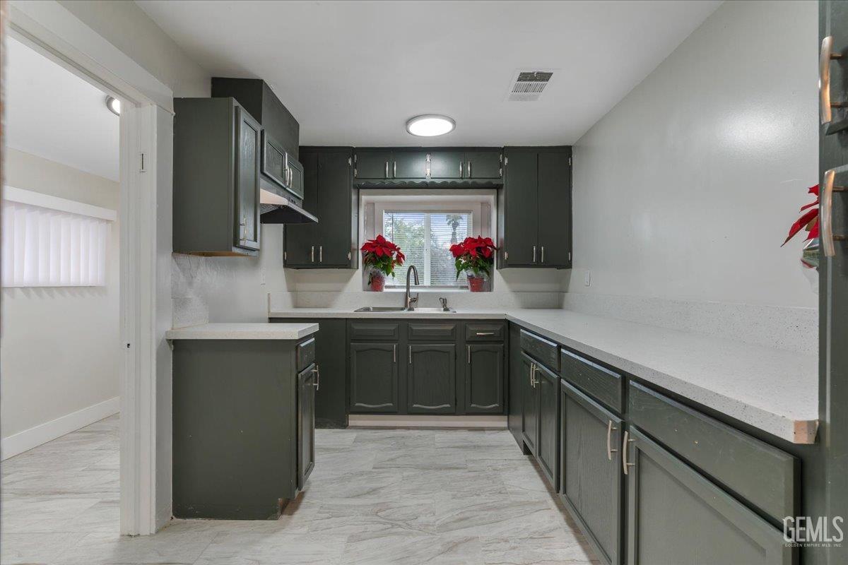 Undisclosed Address Bakersfield, CA 93304 - Photo 14 of 21 a kitchen with kitchen island granite countertop a sink cabinets and window