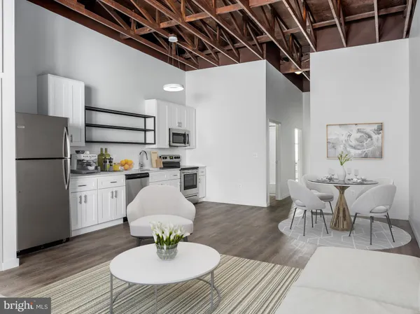 a living room with stainless steel appliances furniture and a table